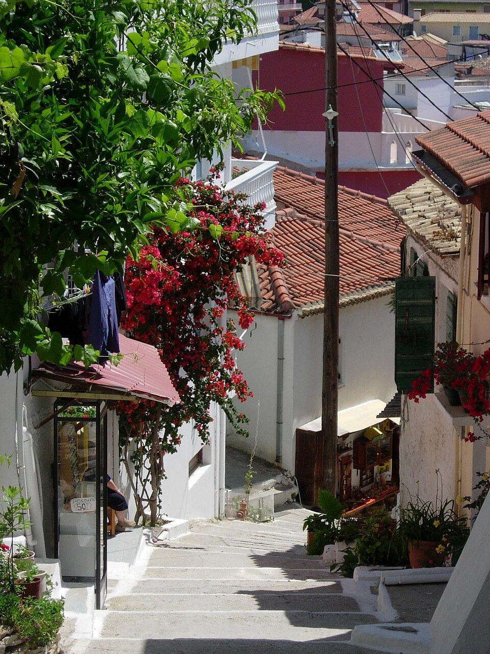 A stepped street in Parga, with white houses, tiled roofs, and bougainvillea.